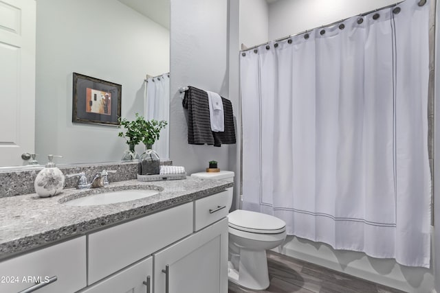 full bathroom with hardwood / wood-style floors, vanity, shower / bath combination with curtain, and toilet