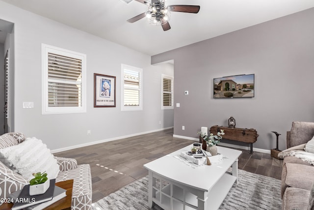 living room featuring dark wood-type flooring and ceiling fan