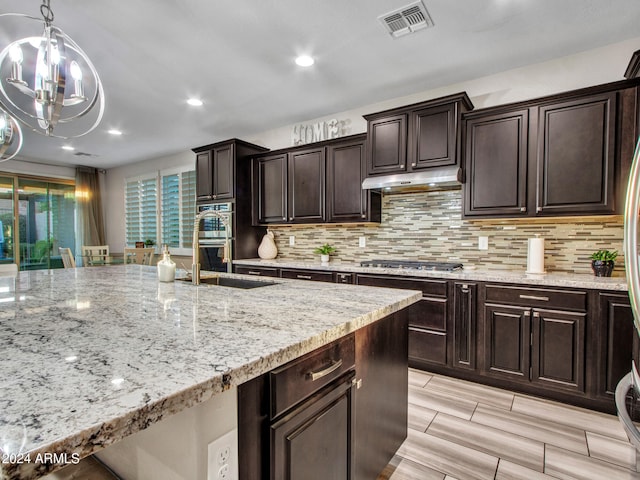 kitchen with appliances with stainless steel finishes, dark brown cabinets, and sink