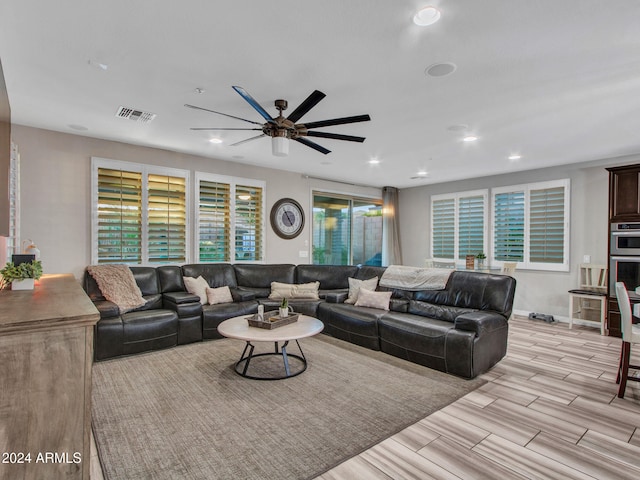 living room with plenty of natural light, light hardwood / wood-style floors, and ceiling fan