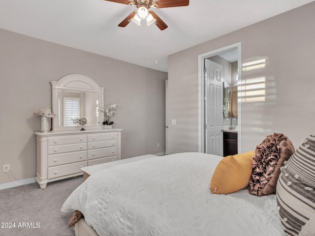 carpeted bedroom with ensuite bath and ceiling fan