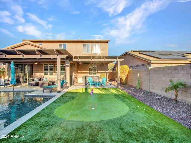 back of house featuring an outdoor living space, a patio area, and a fenced in pool