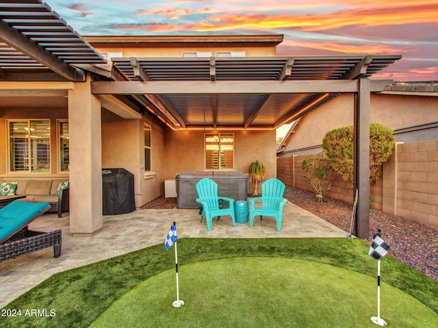 patio terrace at dusk with a pergola and a hot tub