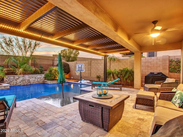 pool at dusk featuring grilling area, ceiling fan, a patio area, and an outdoor hangout area