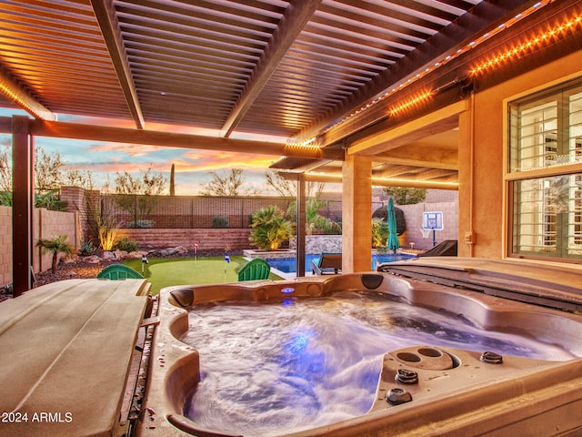 patio terrace at dusk with a pergola and a hot tub