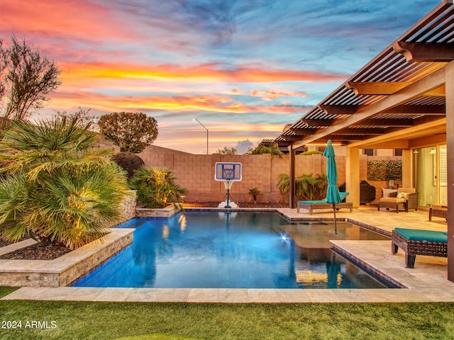 pool at dusk featuring a pergola