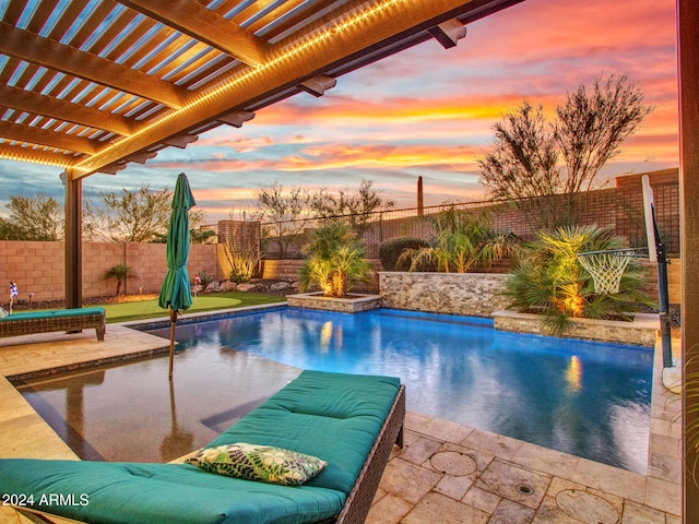 pool at dusk featuring a patio area and a pergola