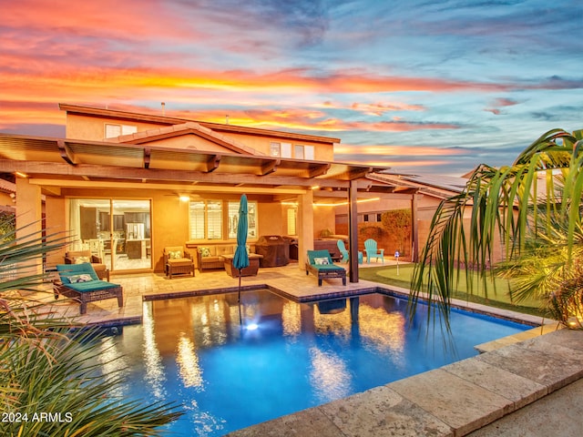 pool at dusk featuring outdoor lounge area and a patio