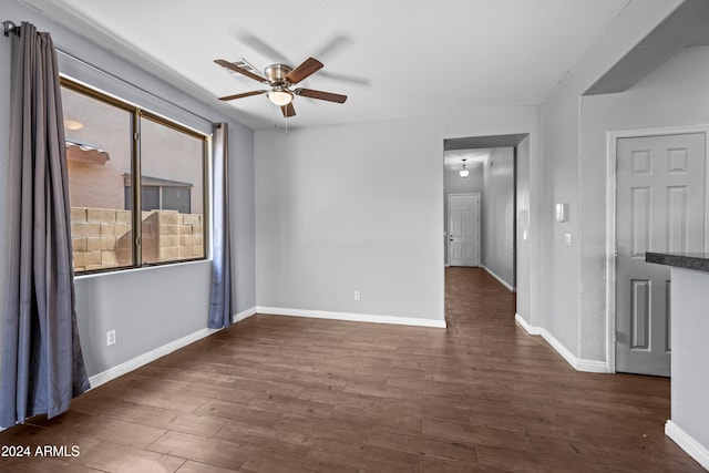 spare room with ceiling fan and dark wood-type flooring