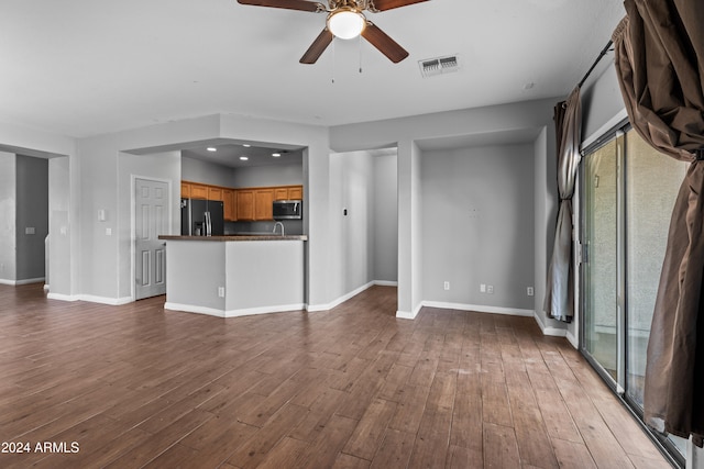 unfurnished living room featuring hardwood / wood-style flooring and ceiling fan