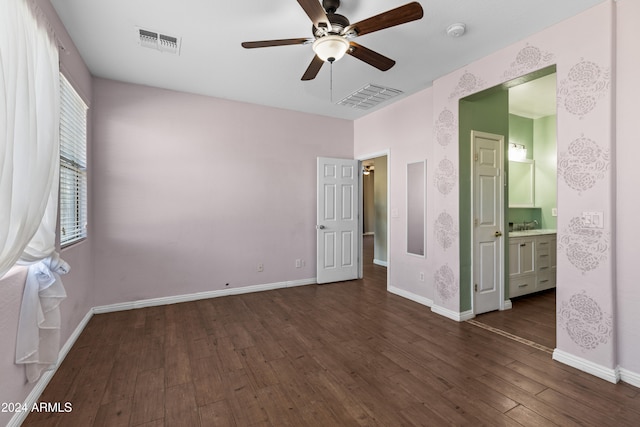 unfurnished bedroom with dark hardwood / wood-style floors, ceiling fan, and connected bathroom