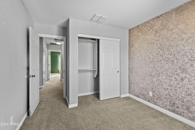 unfurnished bedroom with carpet flooring and a closet