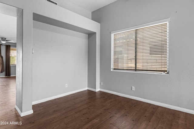 spare room with ceiling fan, dark hardwood / wood-style flooring, and a healthy amount of sunlight