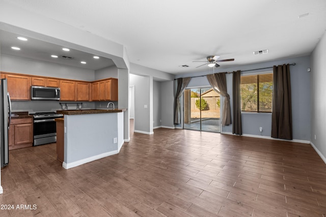 kitchen featuring ceiling fan, dark wood-type flooring, stainless steel appliances, and sink