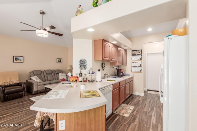 kitchen featuring kitchen peninsula, sink, dark hardwood / wood-style floors, and white appliances