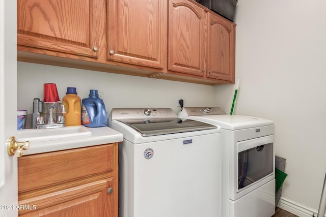 laundry room featuring cabinets, washing machine and dryer, and sink