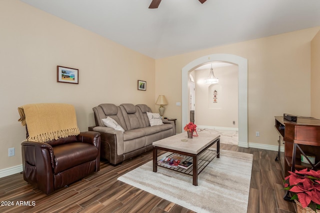 living room featuring ceiling fan and dark wood-type flooring