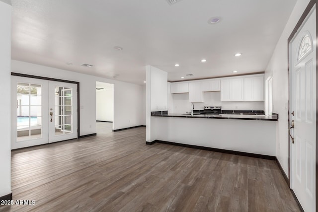 kitchen with kitchen peninsula, french doors, dark hardwood / wood-style floors, and white cabinetry