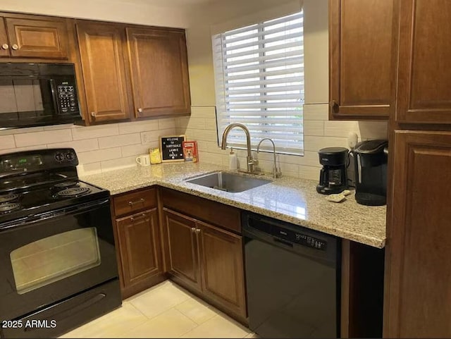 9451 E Becker Ln Unit 1051, Scottsdale, AZ 85260 - kitchen with black appliances, a sink, decorative backsplash, light stone counters, and light tile patterned floors
