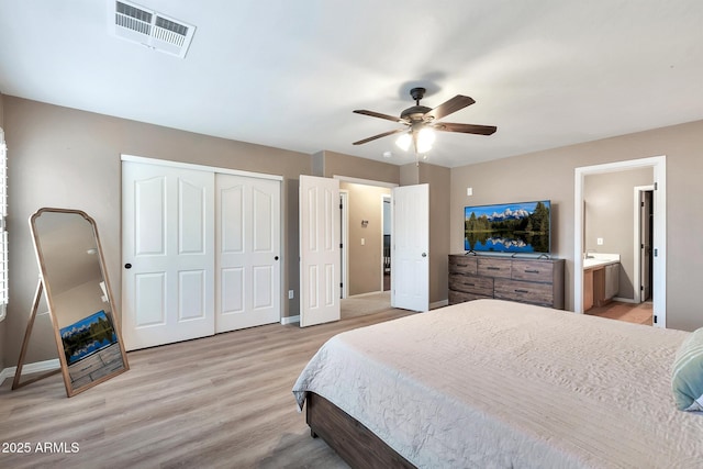 bedroom with ensuite bathroom, ceiling fan, and light hardwood / wood-style flooring