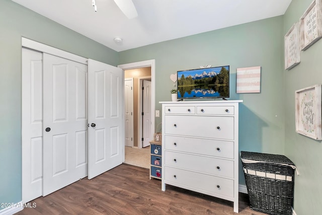 bedroom with ceiling fan, a closet, and dark wood-type flooring