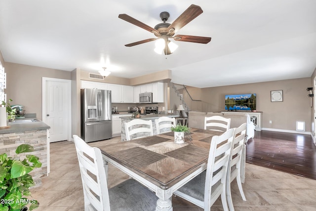 dining room with ceiling fan and sink