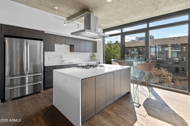 kitchen with a kitchen island, island range hood, dark hardwood / wood-style flooring, expansive windows, and stainless steel appliances