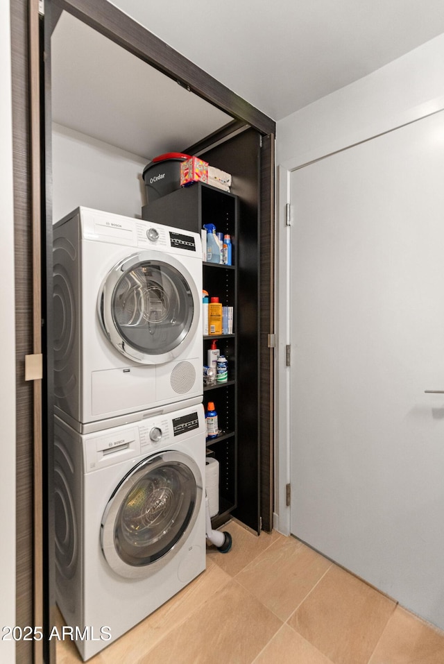 laundry room featuring stacked washer and clothes dryer and light tile patterned flooring