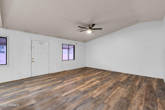 unfurnished room featuring dark hardwood / wood-style flooring, ceiling fan, lofted ceiling, and a textured ceiling