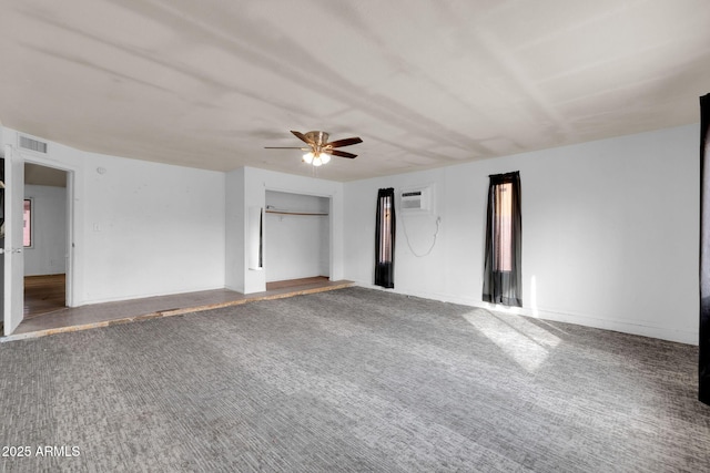 unfurnished bedroom featuring ceiling fan, carpet, a wall unit AC, and a closet