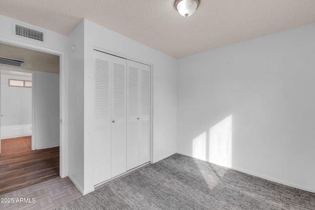 unfurnished bedroom with a textured ceiling and a closet