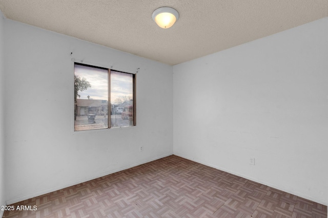 unfurnished room featuring light parquet floors and a textured ceiling