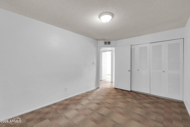 unfurnished bedroom featuring a textured ceiling and a closet