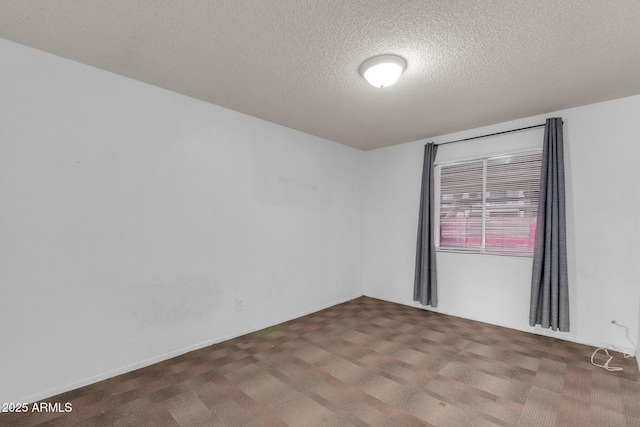 carpeted empty room featuring a textured ceiling