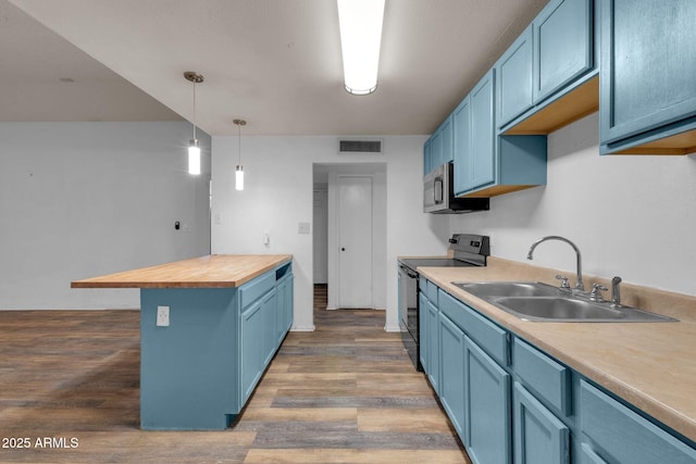 kitchen featuring blue cabinets, butcher block counters, sink, decorative light fixtures, and black electric range