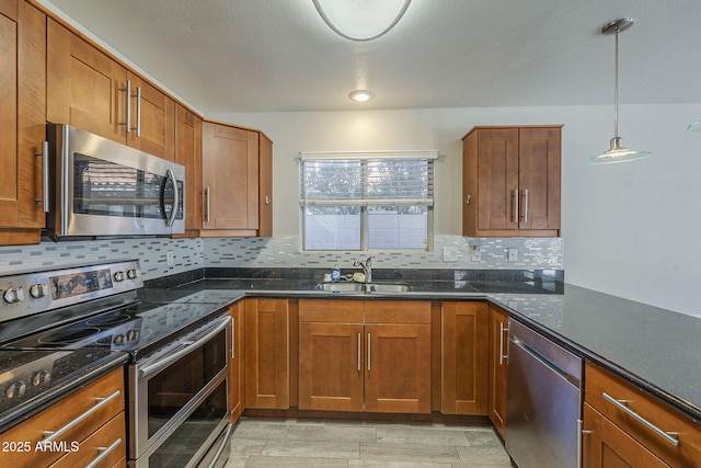 1610 W Maplewood St, Chandler, AZ 85286 - kitchen with appliances with stainless steel finishes, a sink, tasteful backsplash, brown cabinetry, and dark stone countertops