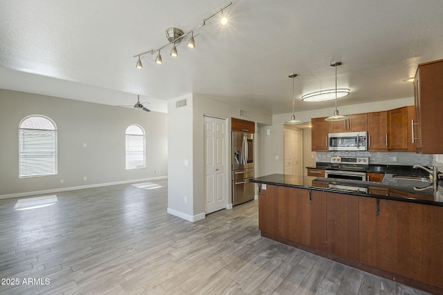 1610 W Maplewood St, Chandler, AZ 85286 - kitchen featuring stainless steel appliances, a sink, dark countertops, baseboards, and brown cabinets