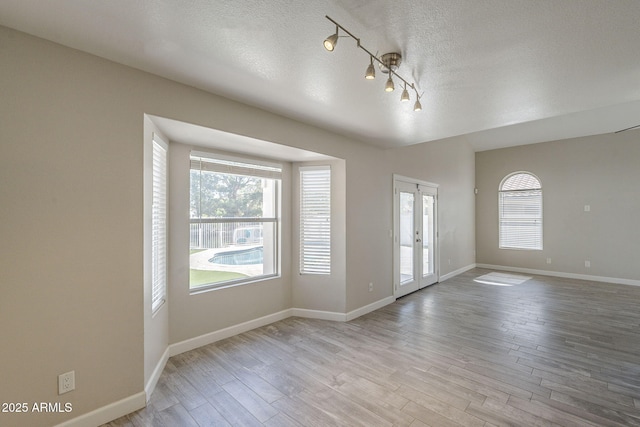 1610 W Maplewood St, Chandler, AZ 85286 - empty room with plenty of natural light, wood finished floors, baseboards, french doors, and a textured ceiling