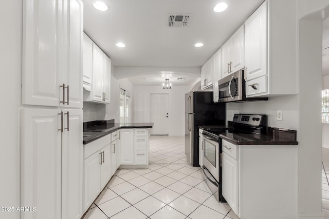 kitchen featuring white cabinetry, light tile patterned floors, stainless steel appliances, and kitchen peninsula