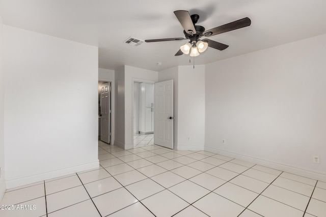 tiled spare room featuring ceiling fan