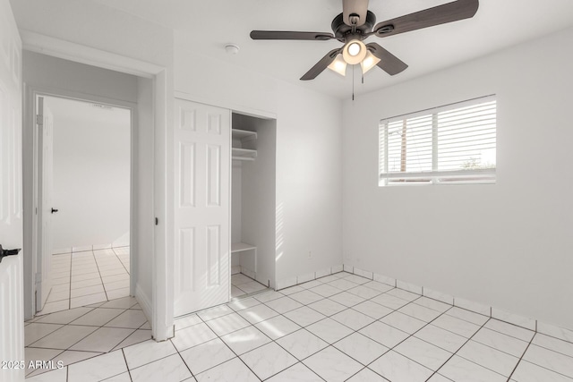 unfurnished bedroom with light tile patterned floors, ceiling fan, and a closet