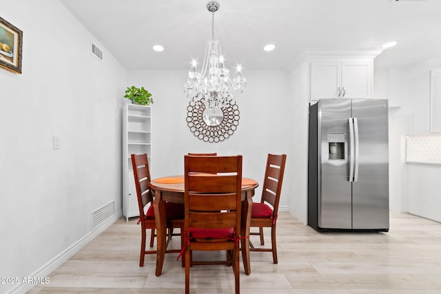 dining room featuring an inviting chandelier and light hardwood / wood-style flooring