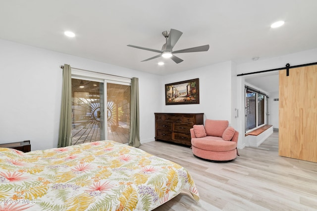 bedroom with ceiling fan, a barn door, light wood-type flooring, and access to outside