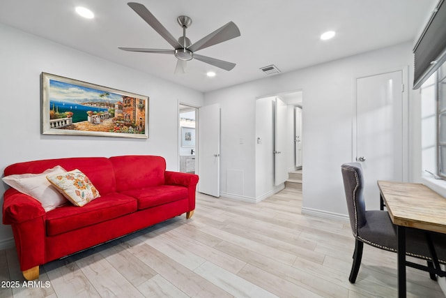 living room featuring light hardwood / wood-style flooring and ceiling fan