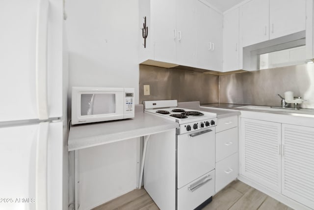 kitchen featuring white cabinetry, white appliances, light hardwood / wood-style floors, and sink