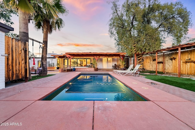 pool at dusk with a patio