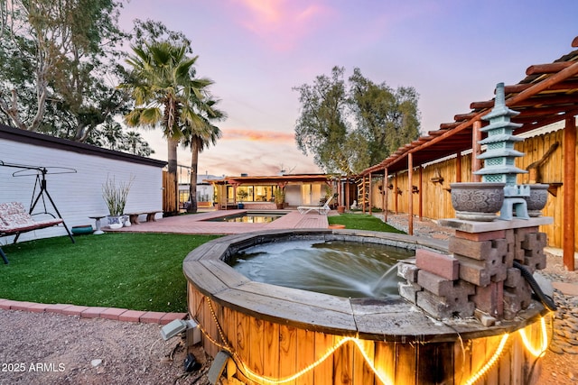 pool at dusk featuring a lawn