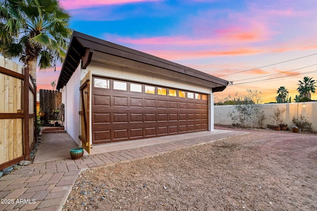 view of garage at dusk