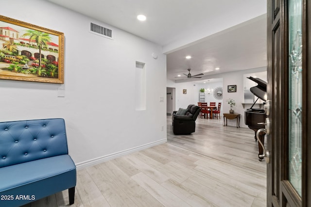 living area featuring ceiling fan and light hardwood / wood-style flooring