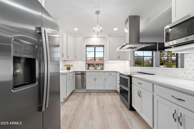 kitchen with white cabinetry, appliances with stainless steel finishes, light wood-type flooring, and island range hood